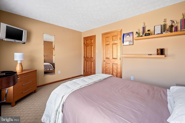 bedroom with a textured ceiling, baseboards, and carpet flooring