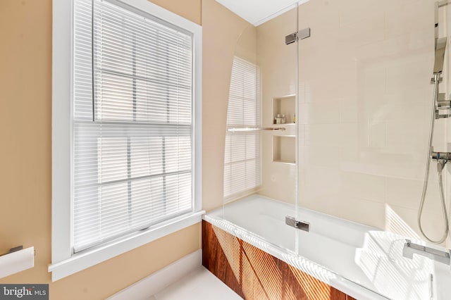 bathroom featuring a healthy amount of sunlight and a shower with door