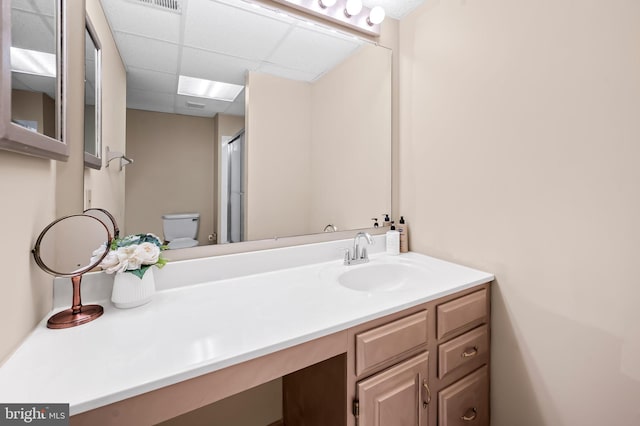 bathroom featuring a shower with shower door, vanity, and toilet