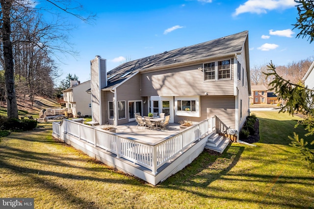 rear view of house featuring a lawn and a deck