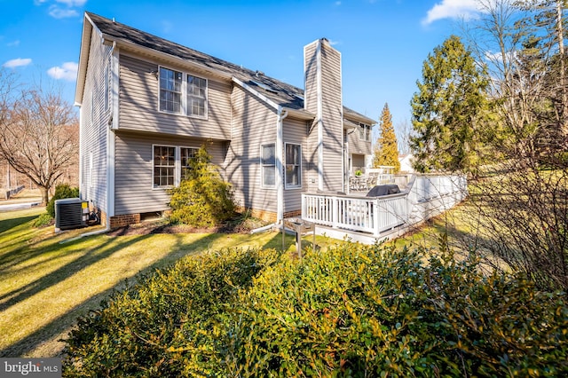 back of property featuring central air condition unit, a chimney, a deck, and a yard