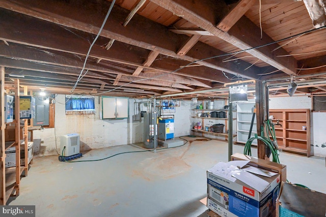unfinished basement featuring electric panel and gas water heater