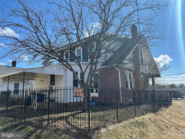 view of front facade featuring a fenced front yard and a chimney