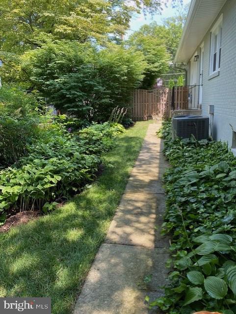 view of yard with fence and central air condition unit