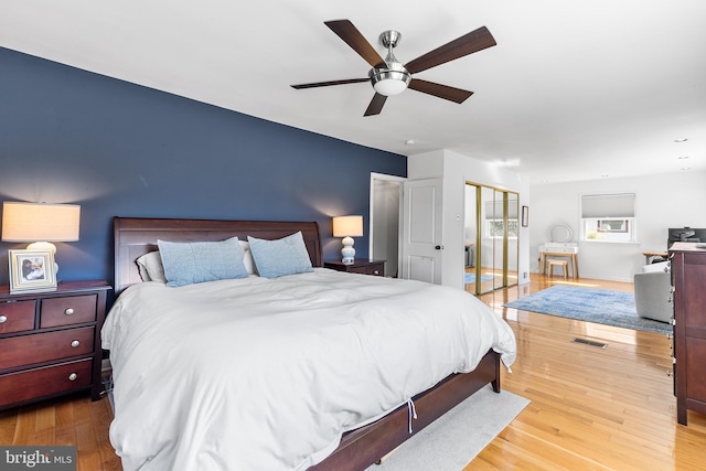 bedroom with a ceiling fan, visible vents, and wood finished floors