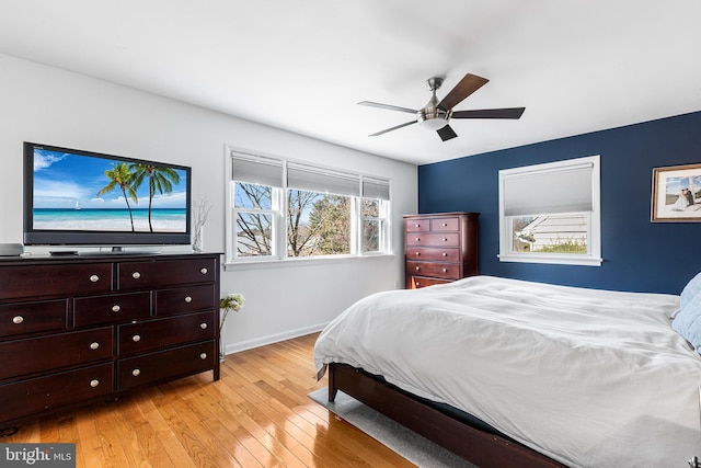 bedroom with light wood-style floors, baseboards, and a ceiling fan