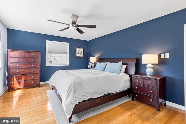 bedroom with baseboards, a ceiling fan, and light wood-style floors