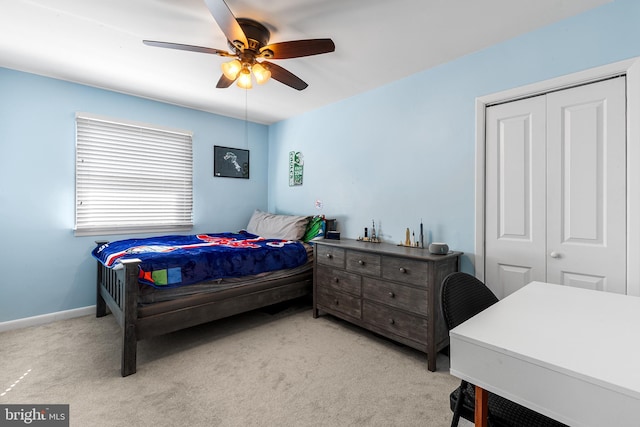 bedroom featuring a closet, light carpet, ceiling fan, and baseboards