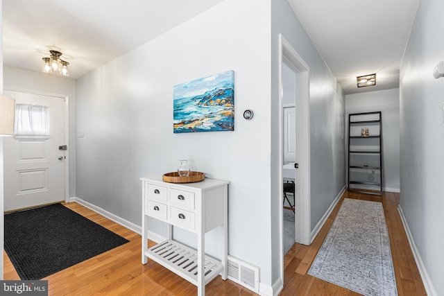 entryway with visible vents, baseboards, and wood finished floors