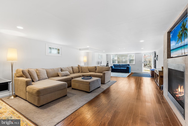 living room featuring recessed lighting, wood finished floors, and a tile fireplace