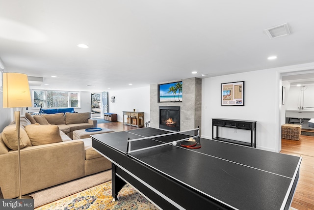 playroom featuring recessed lighting, visible vents, wood finished floors, a tile fireplace, and baseboards