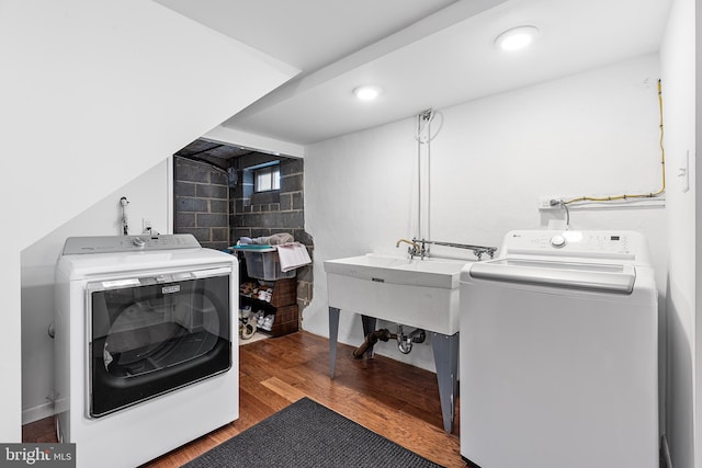 laundry room with a sink, recessed lighting, wood finished floors, and washer and dryer