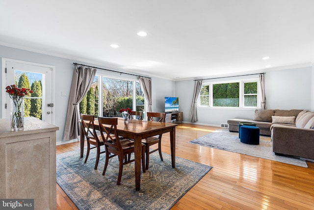 dining room featuring light wood-type flooring, baseboards, and crown molding