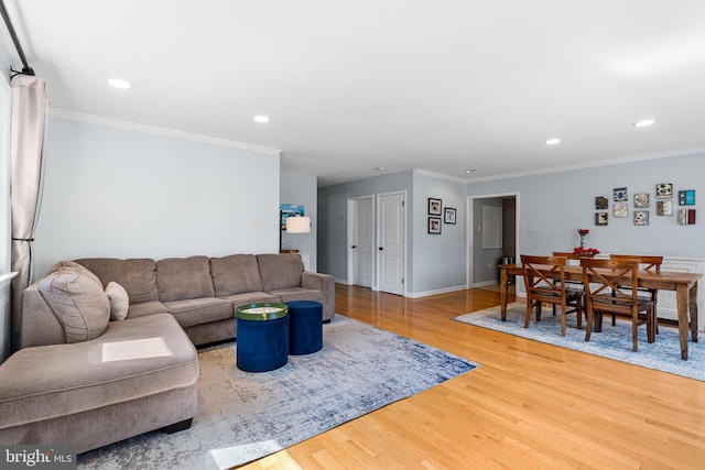 living area with baseboards, recessed lighting, light wood-type flooring, and crown molding