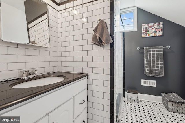 bathroom featuring curtained shower, visible vents, vaulted ceiling, vanity, and baseboards