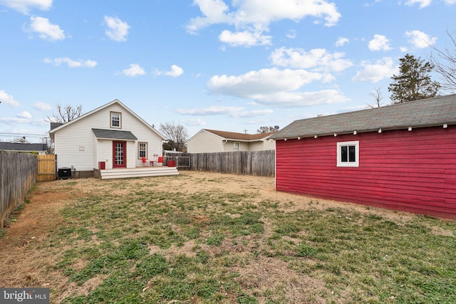 view of yard with a fenced backyard, an outdoor structure, a deck, and central air condition unit