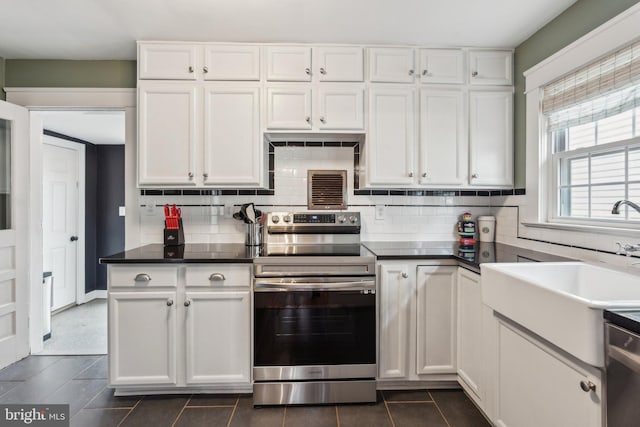 kitchen with stainless steel appliances, white cabinetry, and tasteful backsplash