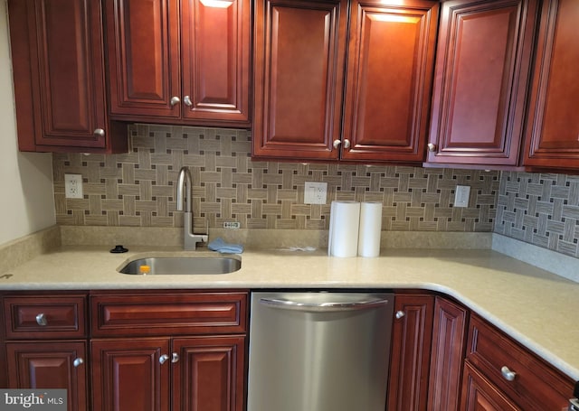 kitchen featuring a sink, reddish brown cabinets, light countertops, and stainless steel dishwasher