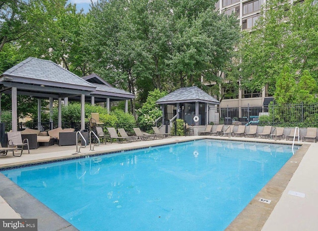 community pool with an outdoor hangout area, a gazebo, a patio area, and fence