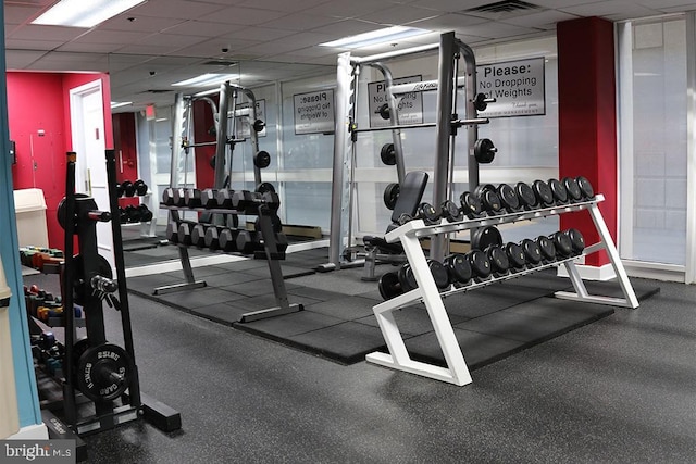 exercise room with a paneled ceiling and visible vents