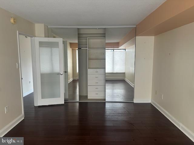 interior space featuring baseboards and dark wood finished floors