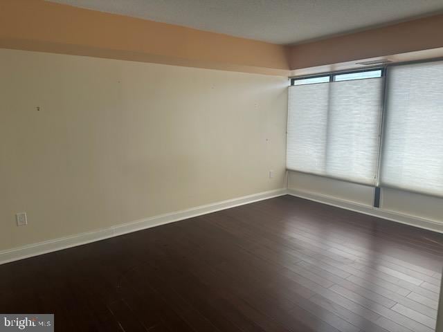 empty room featuring baseboards and wood finished floors