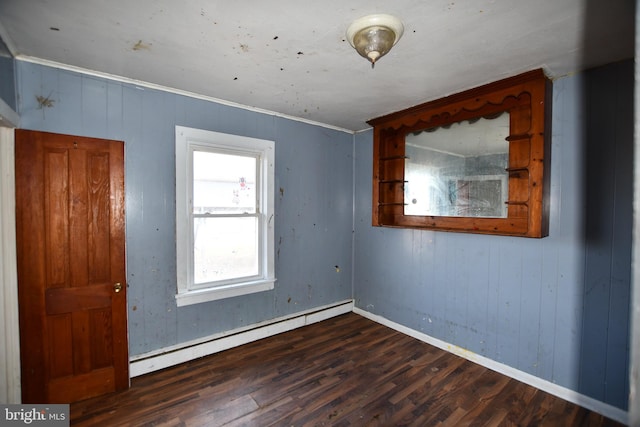 unfurnished room featuring baseboards, crown molding, a baseboard heating unit, and wood finished floors