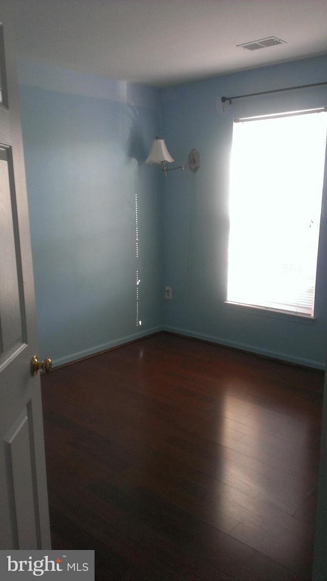 spare room with wood finished floors and visible vents