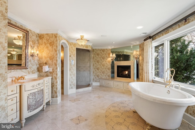 1900 Carrollton Rd, Annapolis, MD 21409 - bathroom with a freestanding bath, vanity, wallpapered walls, a lit fireplace, and ornamental molding
