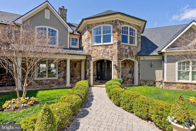 1900 Carrollton Rd, Annapolis, MD 21409 - craftsman-style house with a chimney, a front lawn, roof with shingles, and stone siding