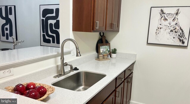 12919 Alton Sq Unit 120, Herndon, VA 20170 - kitchen view of a sink, dark brown cabinets, and light stone countertops