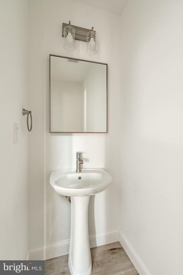 bathroom with baseboards and wood finished floors