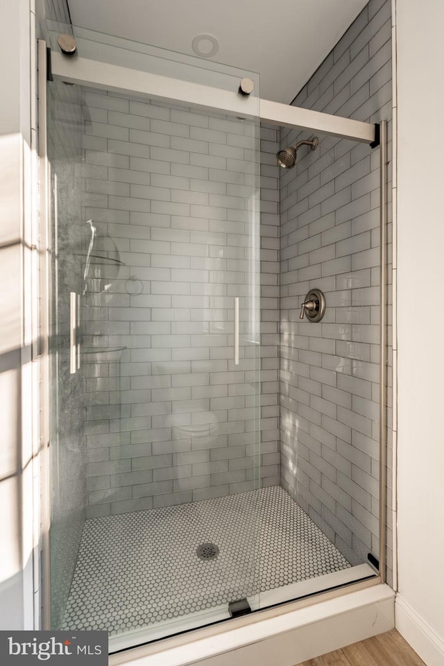 full bath featuring a stall shower and wood finished floors