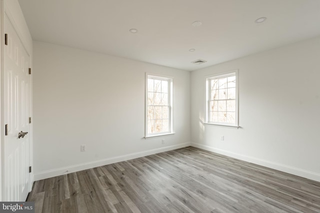 unfurnished bedroom featuring visible vents, baseboards, and wood finished floors