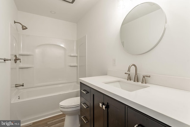 bathroom featuring vanity, tub / shower combination, wood finished floors, and toilet