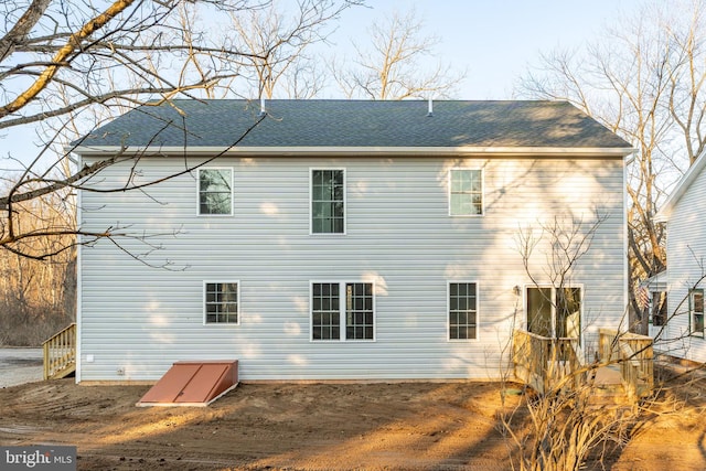 back of property with roof with shingles