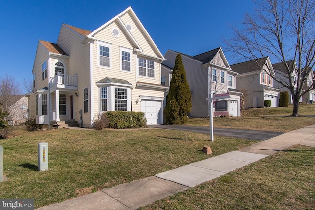 view of front of house with a garage, a balcony, a front yard, and aphalt driveway