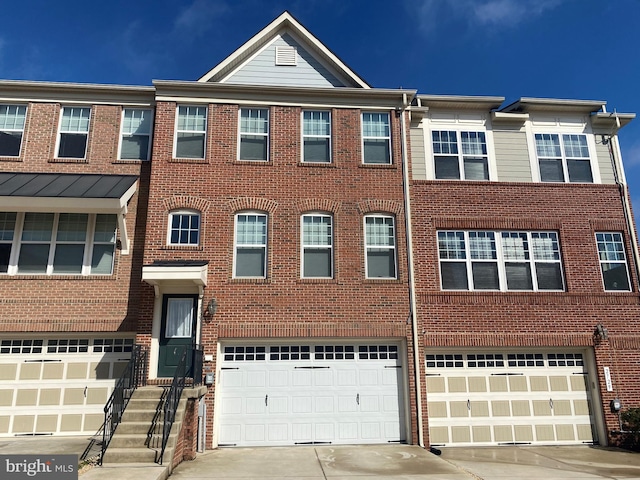 multi unit property featuring a garage, concrete driveway, and brick siding