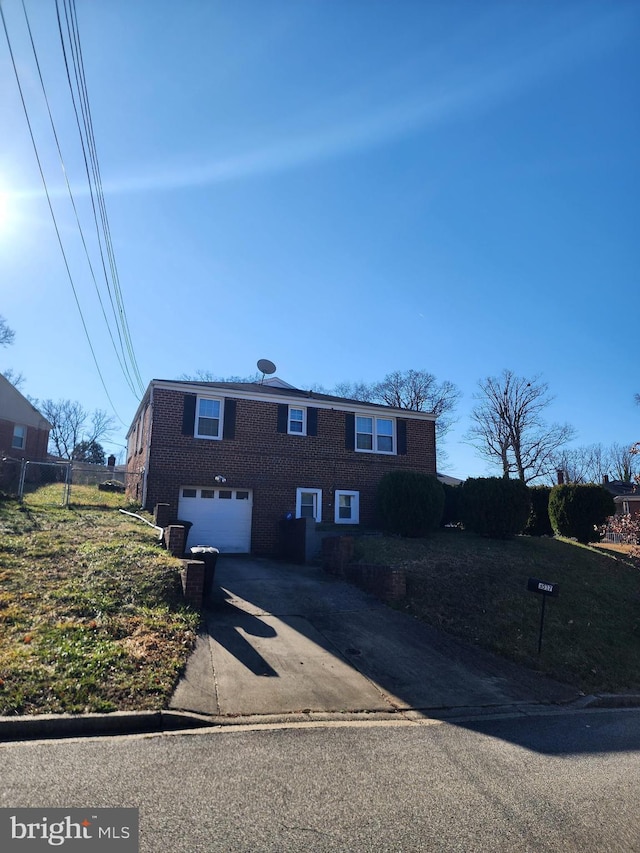 view of front of house with a garage, driveway, brick siding, and fence