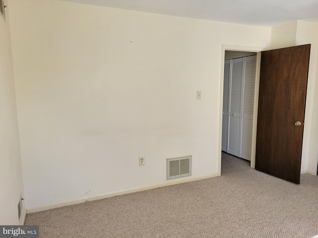 unfurnished bedroom with carpet floors, a closet, visible vents, and baseboards