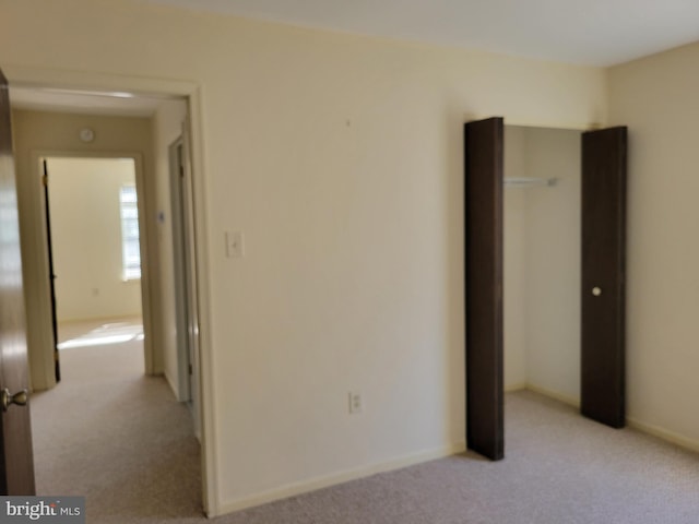 unfurnished bedroom featuring light colored carpet and baseboards