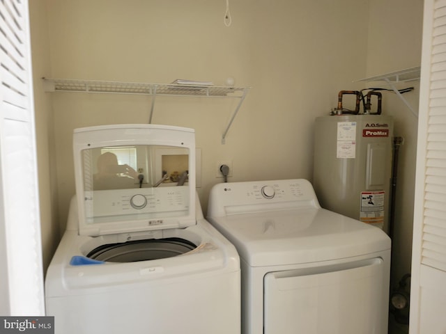 laundry room featuring laundry area, electric water heater, and separate washer and dryer