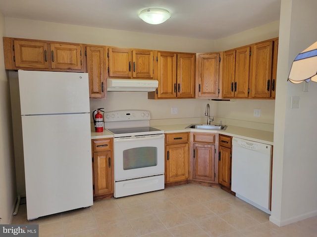 kitchen featuring white appliances, a sink, exhaust hood, light countertops, and brown cabinetry