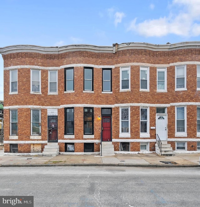 townhome / multi-family property featuring entry steps and brick siding