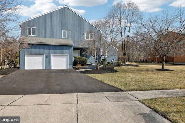 view of home's exterior featuring aphalt driveway, a garage, and a yard