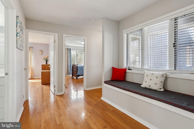 hallway with light wood-style flooring and baseboards