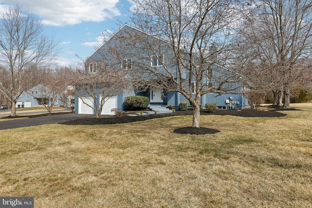 view of front of property featuring aphalt driveway, an attached garage, and a front lawn