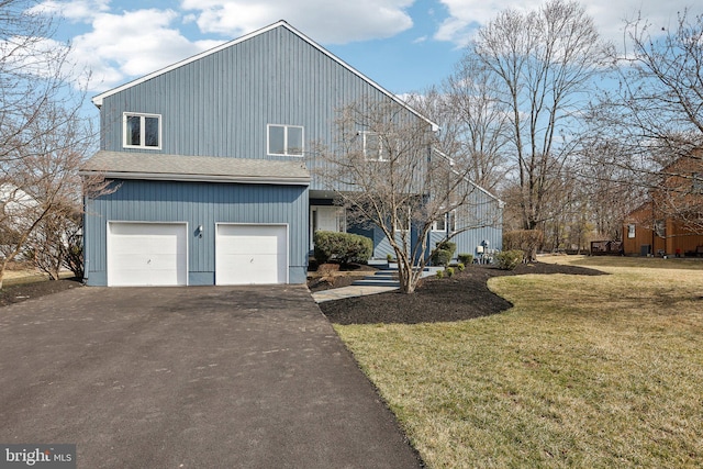 view of front of house with driveway, an attached garage, and a front lawn