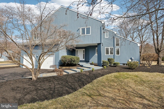 view of front of house featuring a garage, driveway, and a front yard