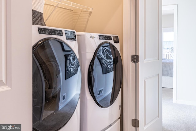 laundry area with laundry area, washing machine and dryer, and carpet